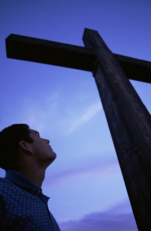 boy looking up at cross